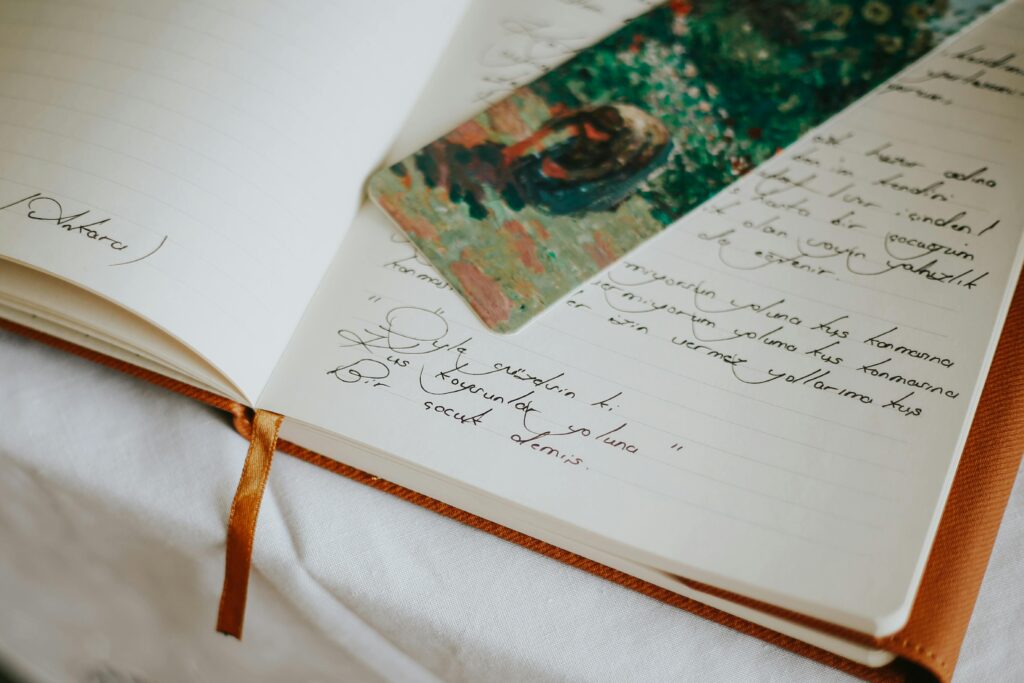A close-up of an open journal with handwritten text and a colorful bookmark, evoking creativity.